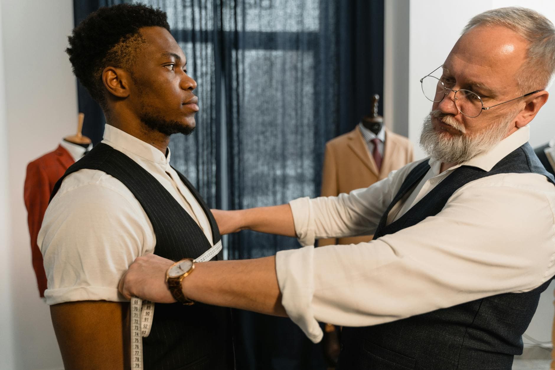 Tailor fitting a suit on a client